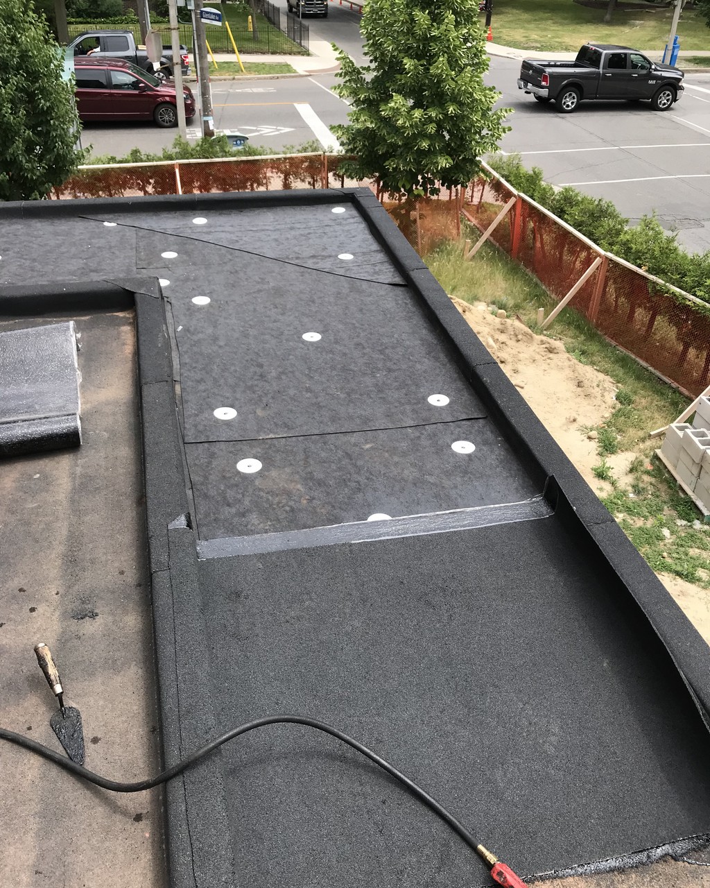 Sloped insulation of torch applied membrane on flat roof in Toronto