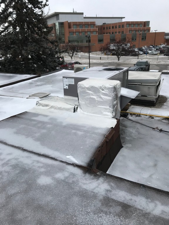 Aluminum foil wrap on flat roof institutional facility in Markham