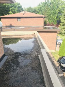Water ponding in tar and stone flat roof in Markham